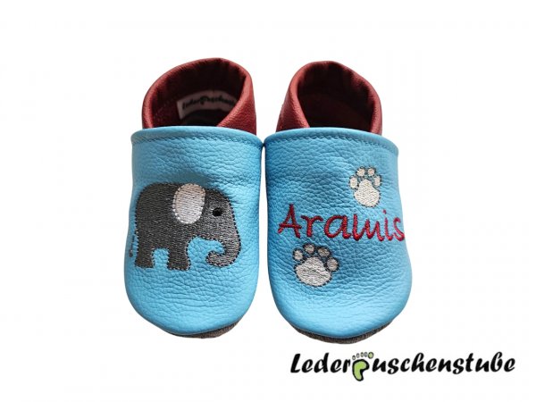 Lederpuschen hellblau-dunkelrot mit rechts Elefant und links Namen dunkelrot und Fußabdruck